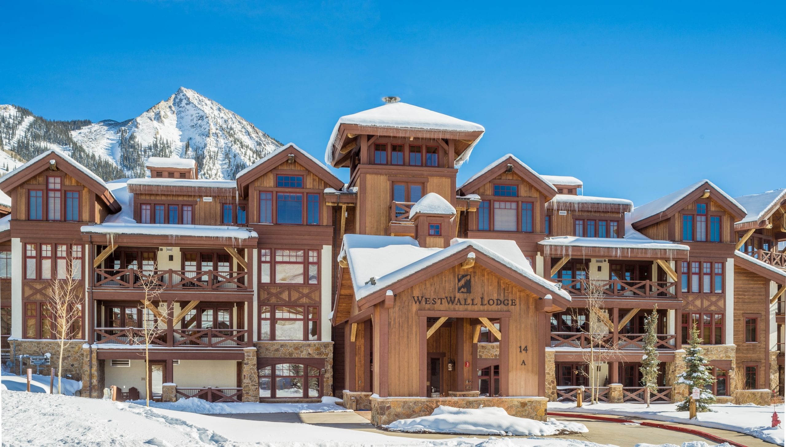 WestWall Lodge exterior in winter with the peak of Mt Crested Butte in the background