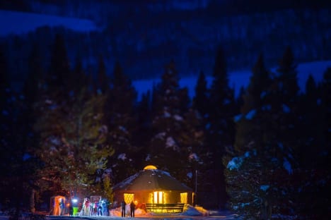 Magic Meadows Yurt lit up at night outside Crested Butte