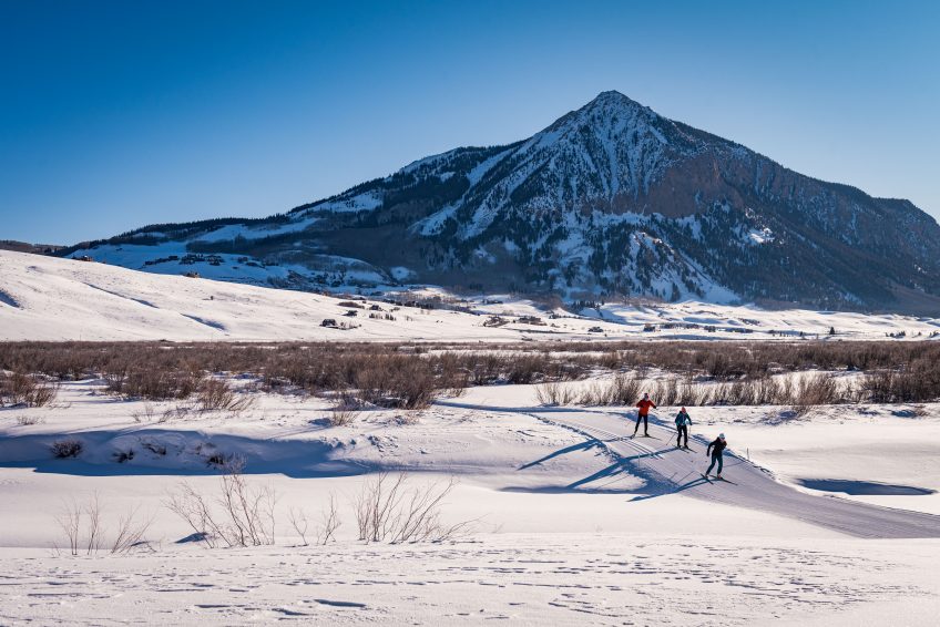 Skiers on Peanut Lake trails with Mt Crested Butte in background
