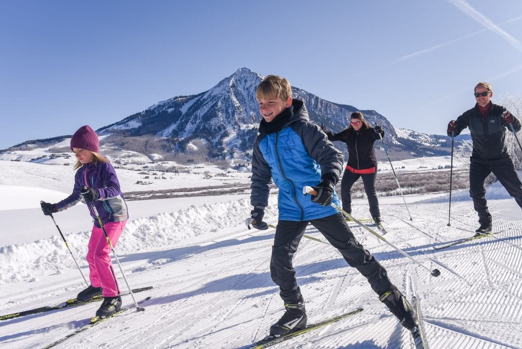 Family out for a skate ski with Mt Crested Butte in background