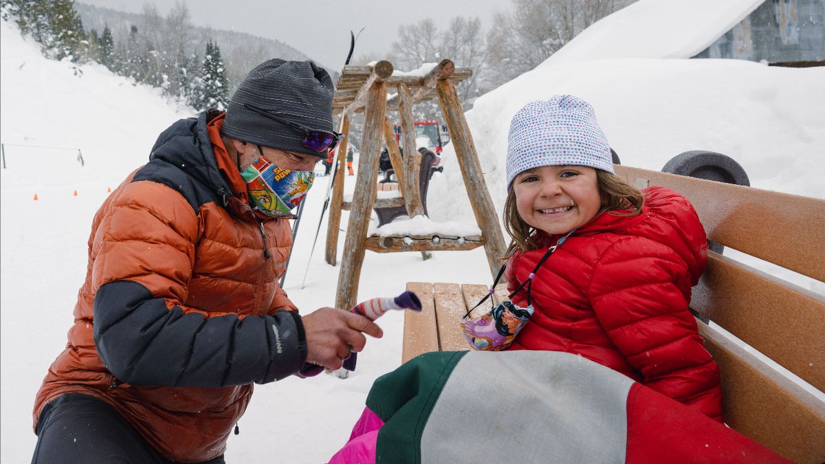 Young skier gets help from a volunteer at Crested Butte Nordic