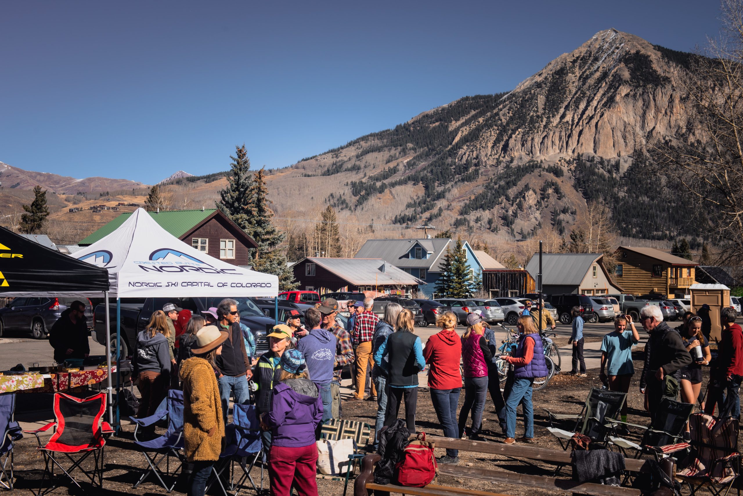 The CB Nordic community gathers outside the Nordic Center for the Annual Potluck with Mt. Crested Butte in the background.
